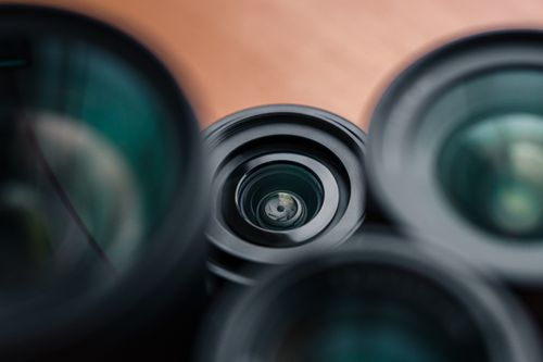 Free Artistic close-up of camera lenses on a wooden surface, showcasing focus and aperture details. Stock Photo