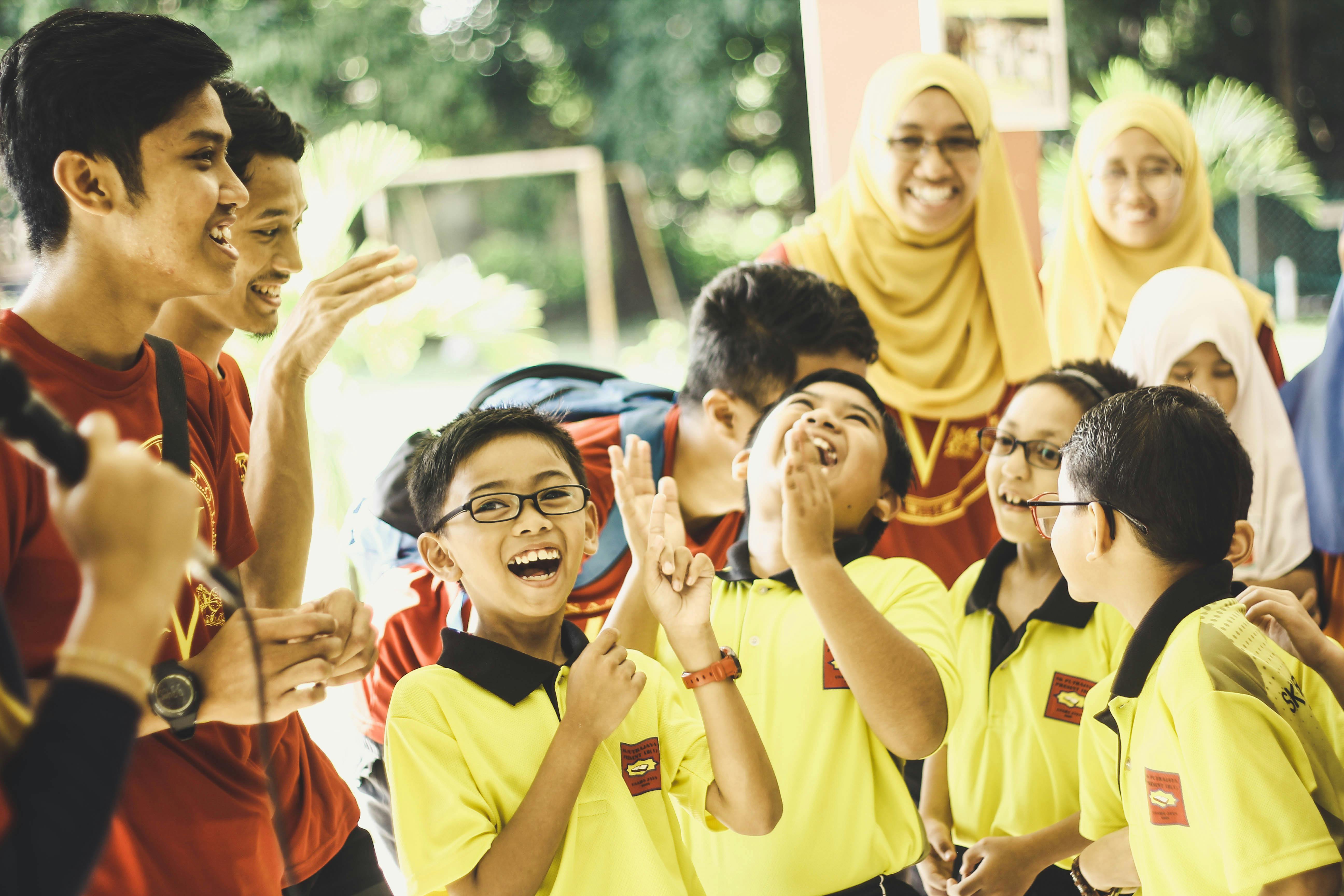 laughing children in between woman and man at daytime