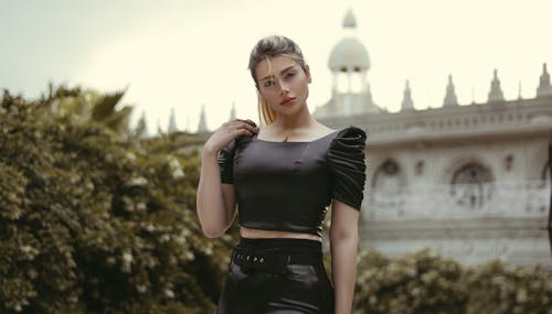 Woman in Black Crop Top Posing with Hand on Shoulder
