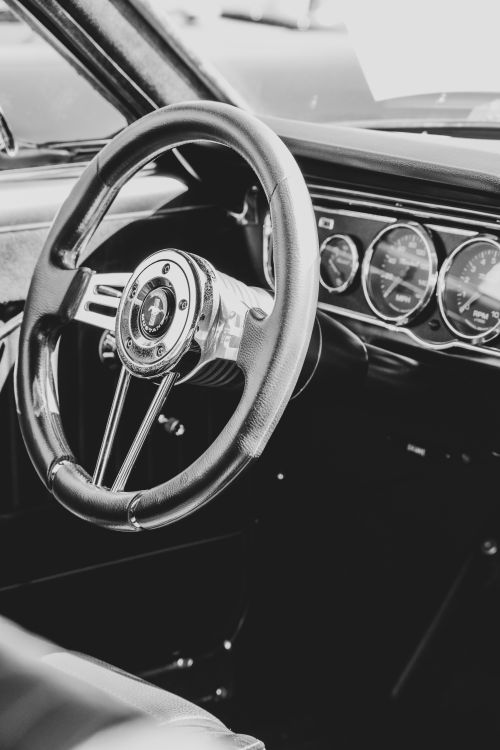 Free Black and white close-up of classic Ford Mustang steering wheel showcasing vintage elegance. Stock Photo