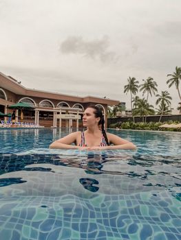 Woman enjoying a serene moment in a resort pool in Unawatuna, Sri Lanka.