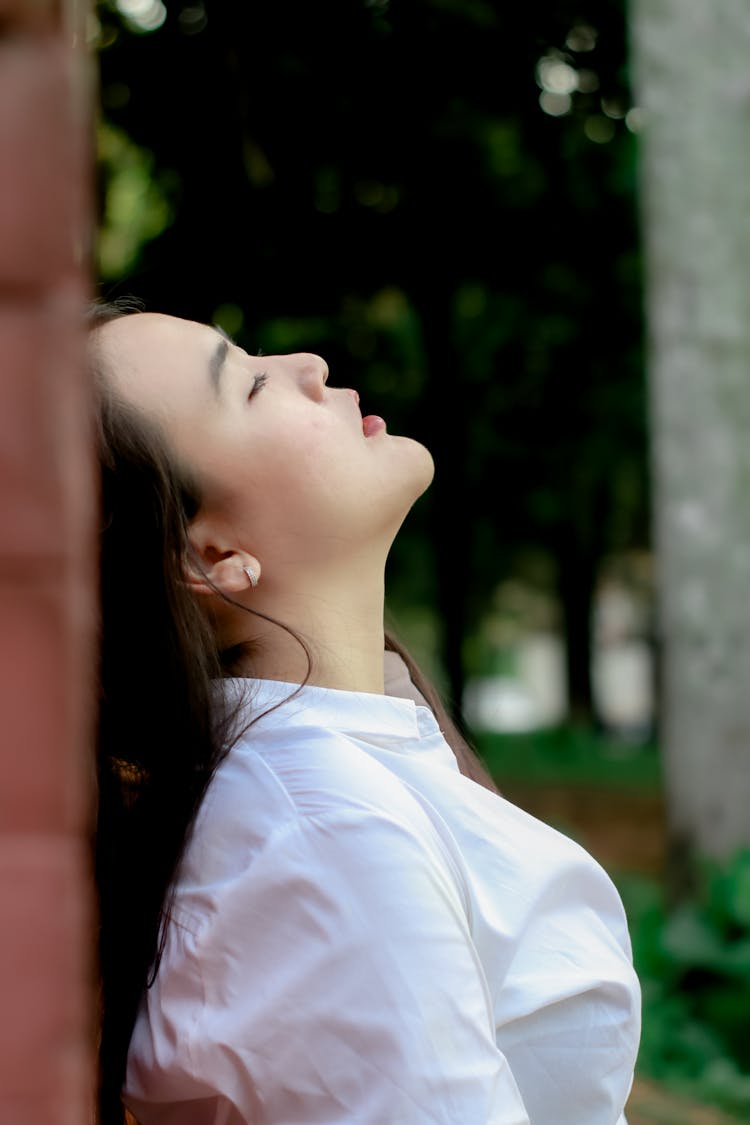 Side View Of A Woman Leaning On The Wall