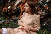 Woman in Brown Button Up Long Sleeve Shirt Sitting on Green Grass