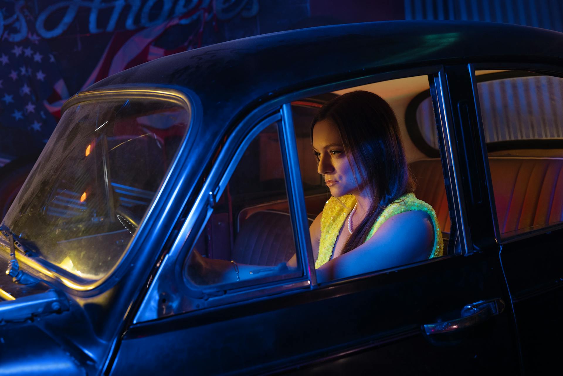 Elegant woman in a classic car during a nighttime drive in Los Angeles.