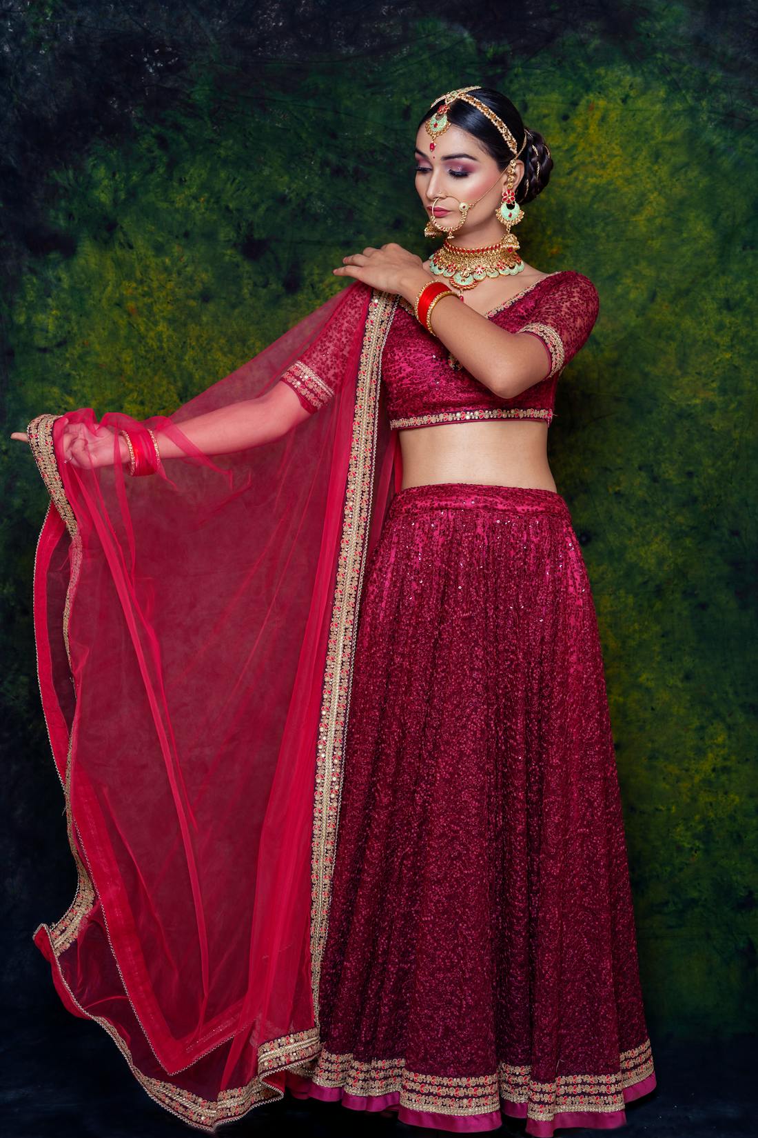 Bride twirling in a rich red Kanjivaram lehenga with zari border