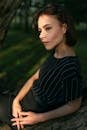 Woman in Black and White Striped Off Shoulder Dress Sitting on Black Chair