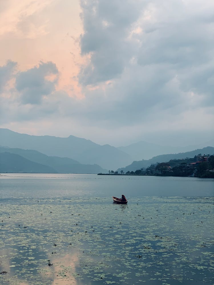 Lonely Man On Boat On Big Mountain Lake