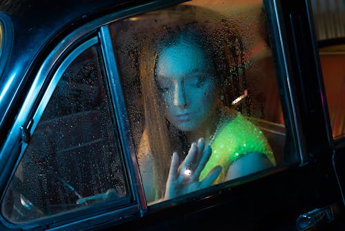 Free A Sad Woman Looking through the Window while Sitting Inside the Car Stock Photo
