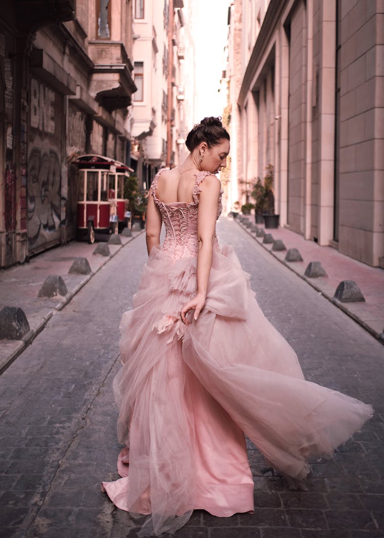 Back View Of A Woman Walking Down The Street