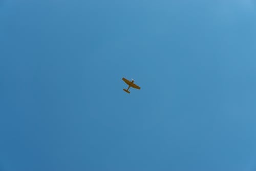 Yellow Plane Flying Under Blue Sky