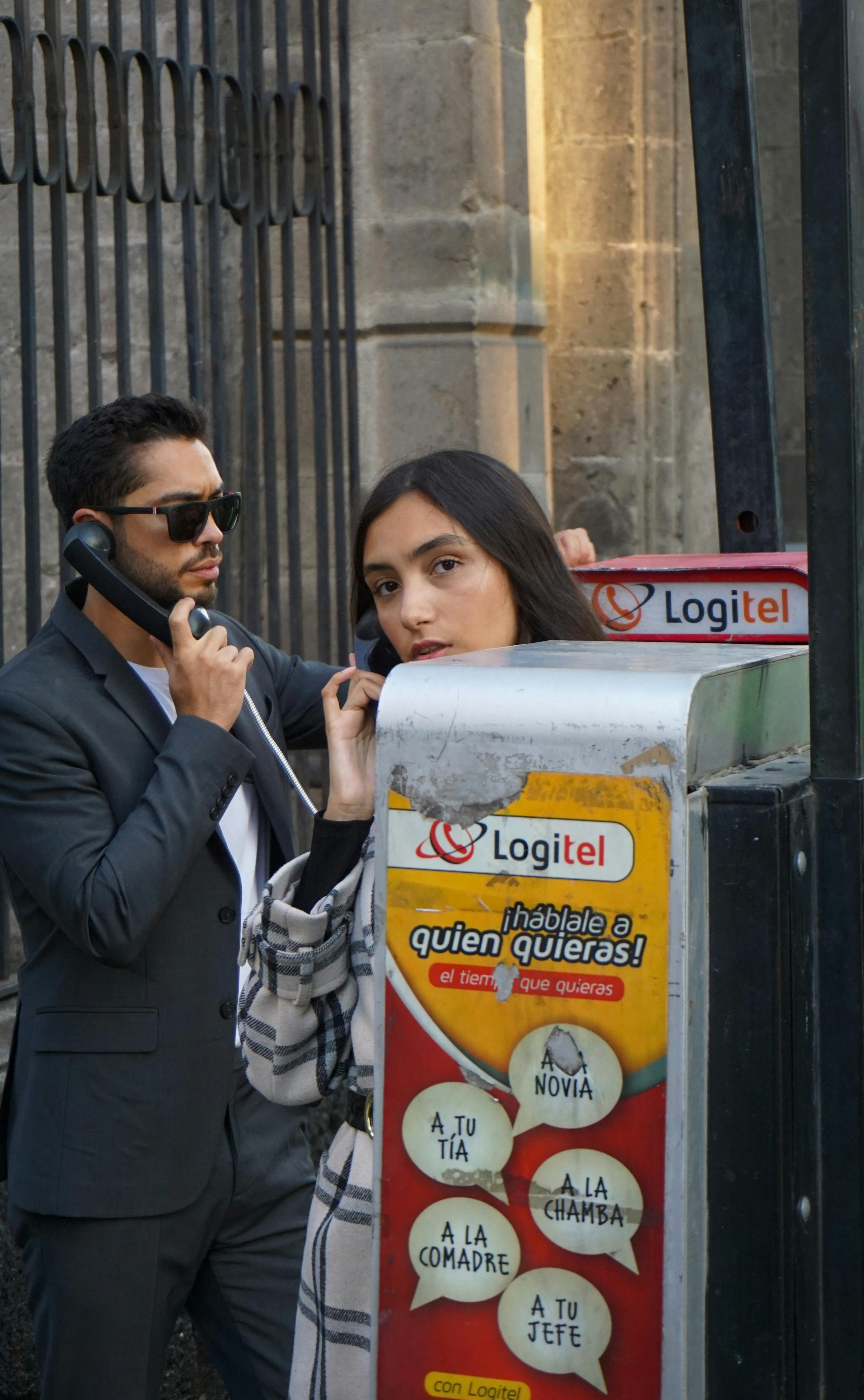 Man and Woman Using Public Phone · Free Stock Photo