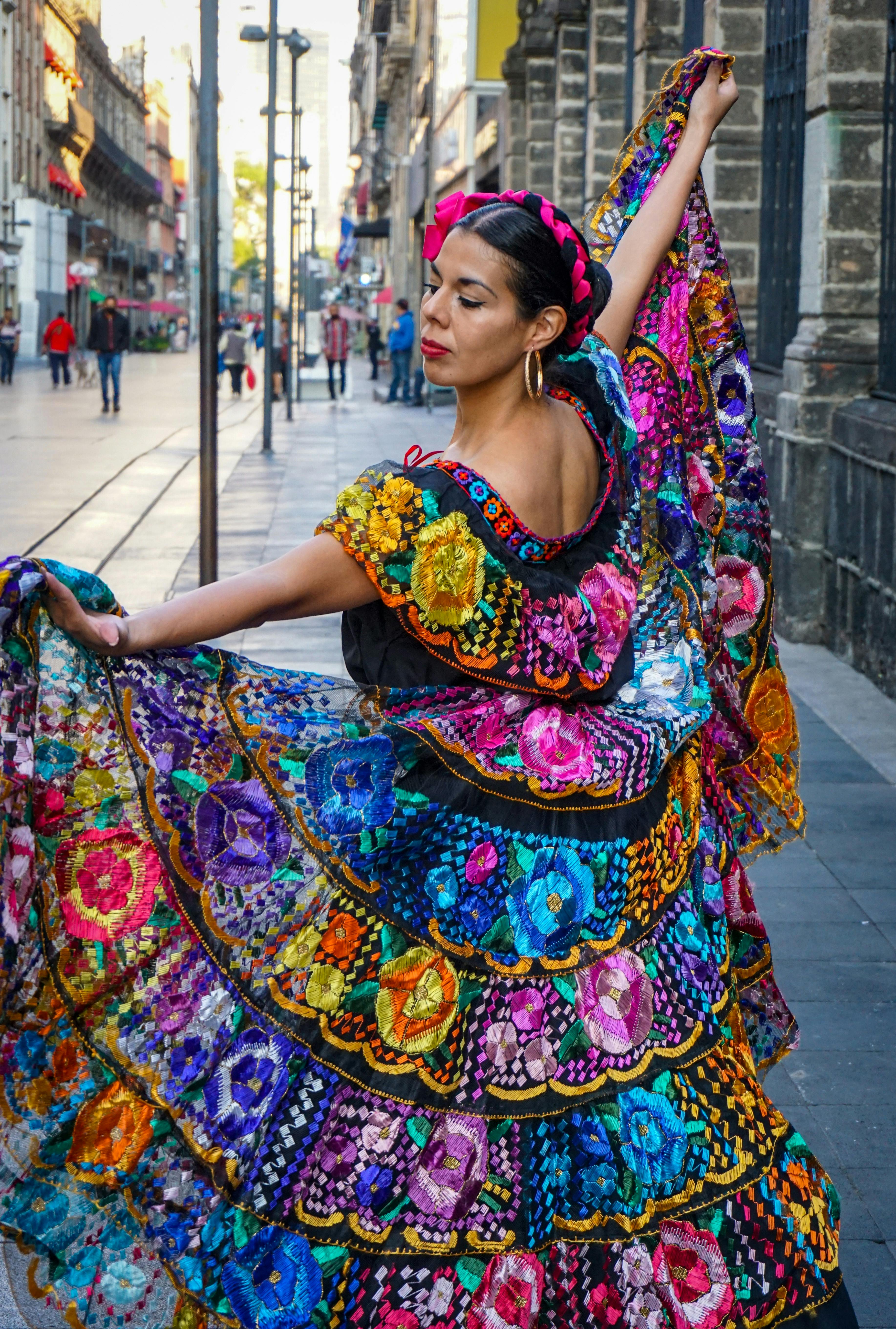 Free Woman Wearing a Traditional Dress Dancing on the Sidewalk Stock Photo