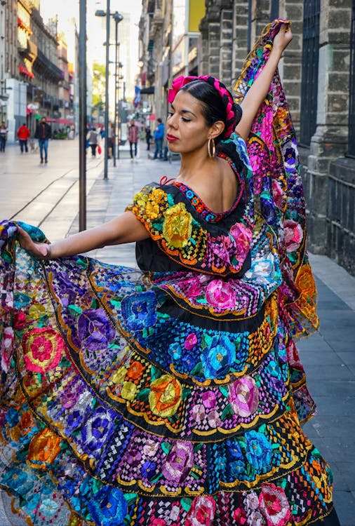 Free Woman Wearing a Traditional Dress Dancing on the Sidewalk Stock Photo