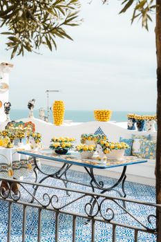 A vibrant outdoor table setting featuring lemons and Mediterranean decor on a sunny day.