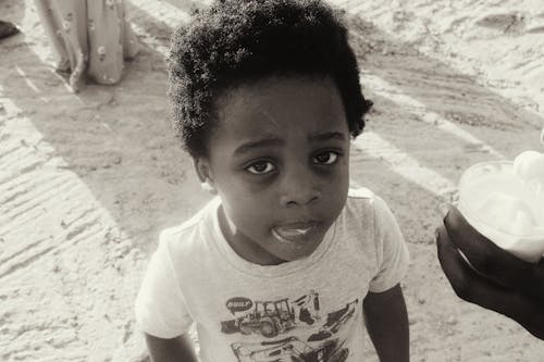 Black and White Shot of a Boy Eating Ice Cream