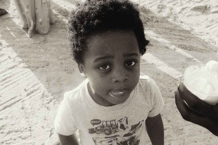 Black And White Shot Of A Boy Eating Ice Cream