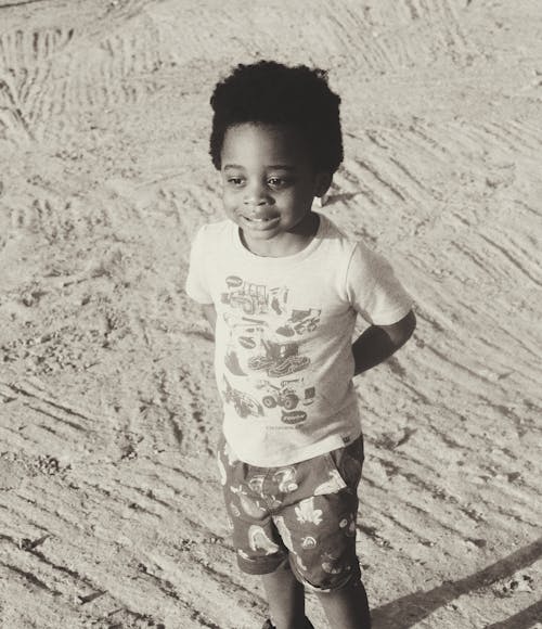 Black and White Photo of Boy on Beach