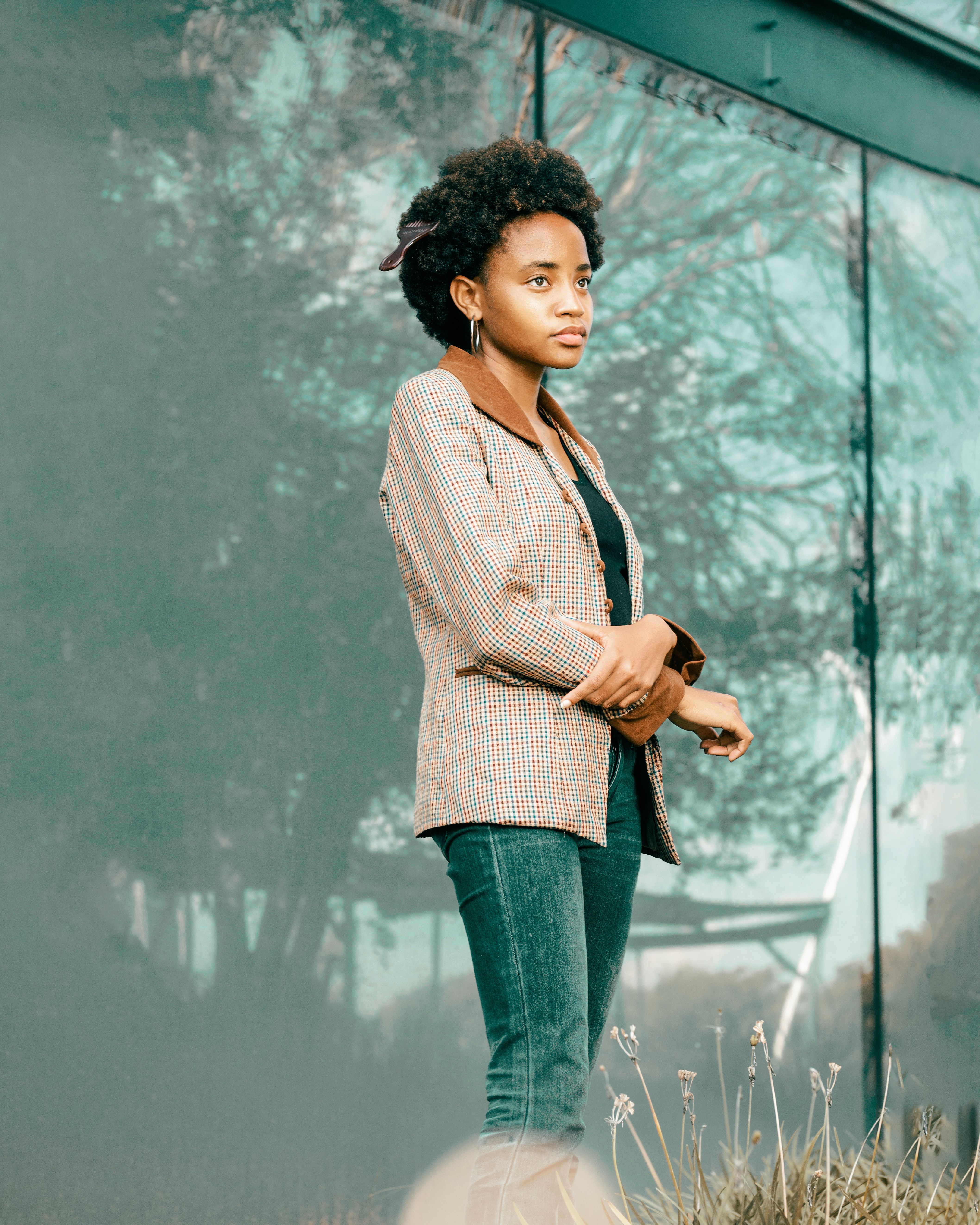 Woman wearing a checked blazer with dark jeans in smart casual style