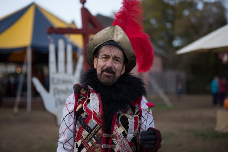 A Man Wearing A Medieval Costume Holding A Flower