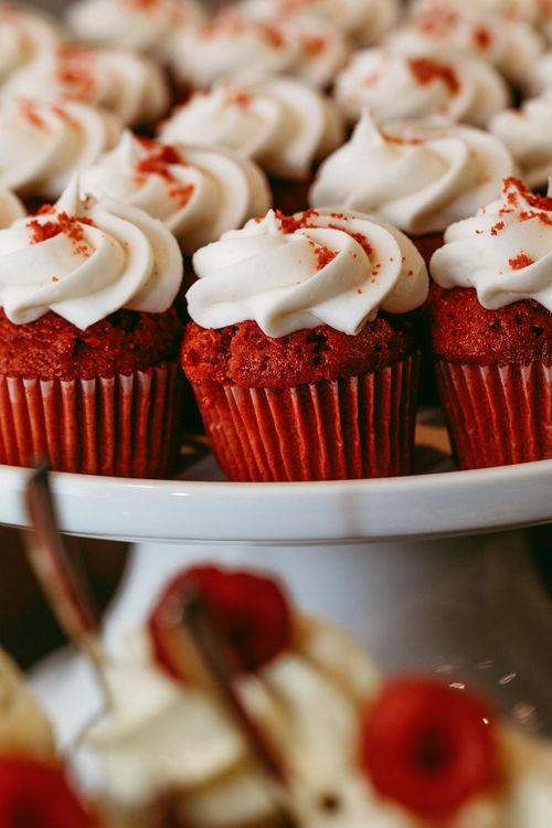 Free Close-up of red velvet cupcakes topped with rich cream cheese frosting, perfect for any celebration. Stock Photo