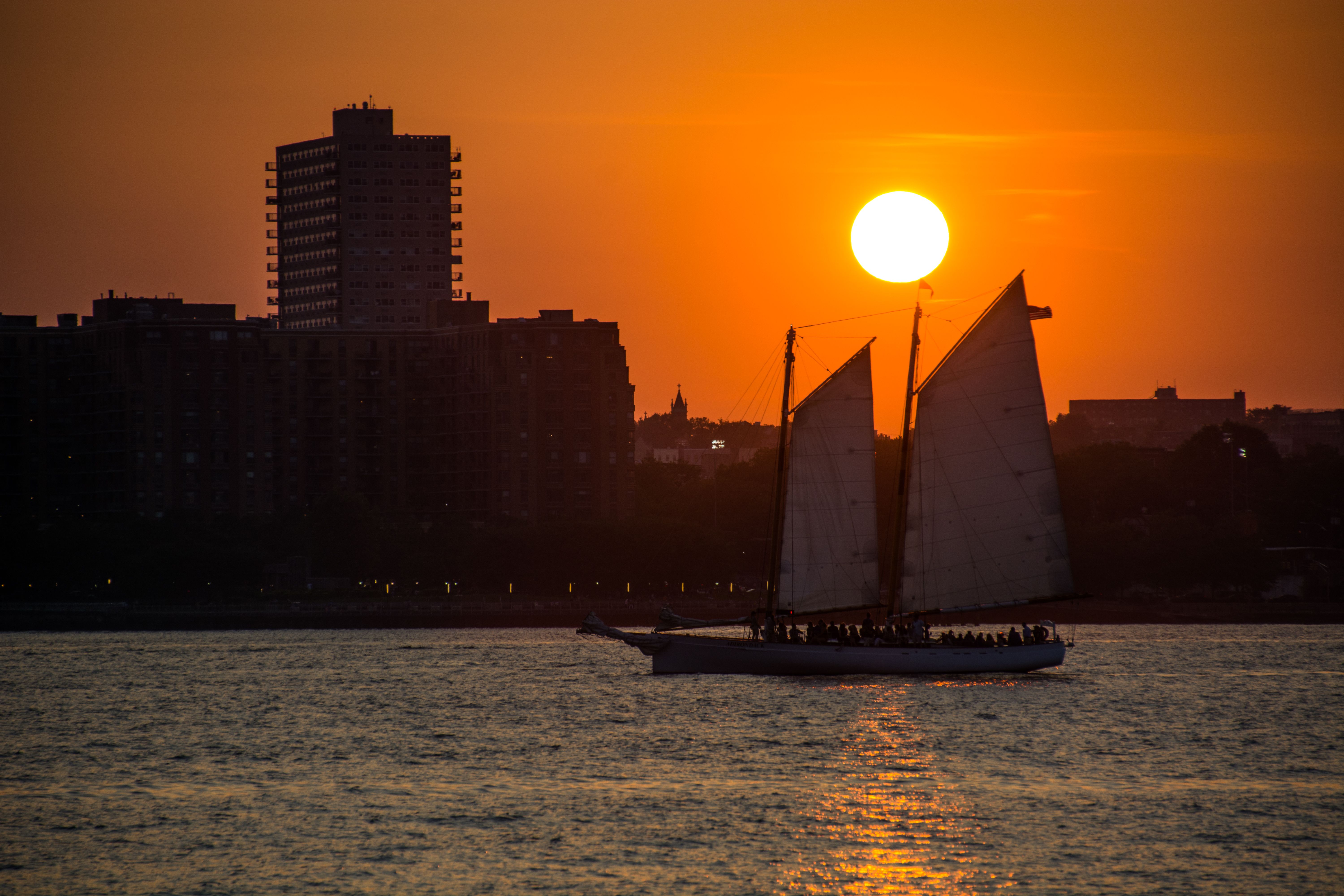 Unbeatable New York City Cocoa and Carols Holiday Cruise Review: A Festive Floating Celebration Review 2026 - A sailboat sails along the New York City skyline at sunset, creating a picturesque scene.