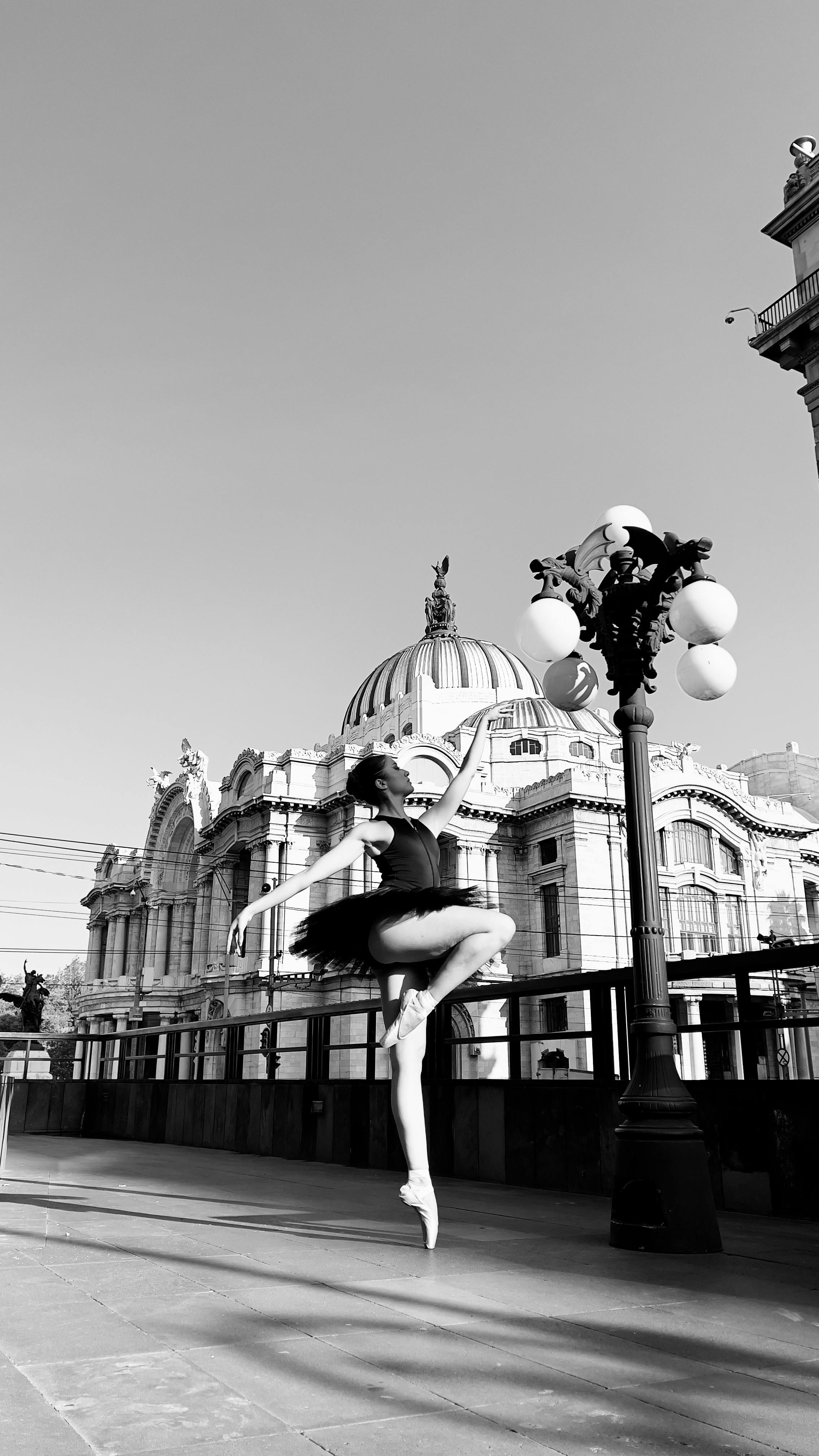 grayscale photo of a woman dancing on the street