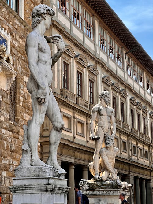 Statues of Nude Men Beside Brown Building