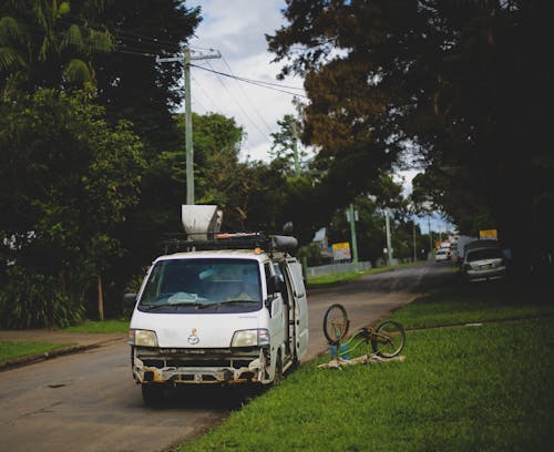 A Bicycle on a Grassy Ground Beside an Old Van