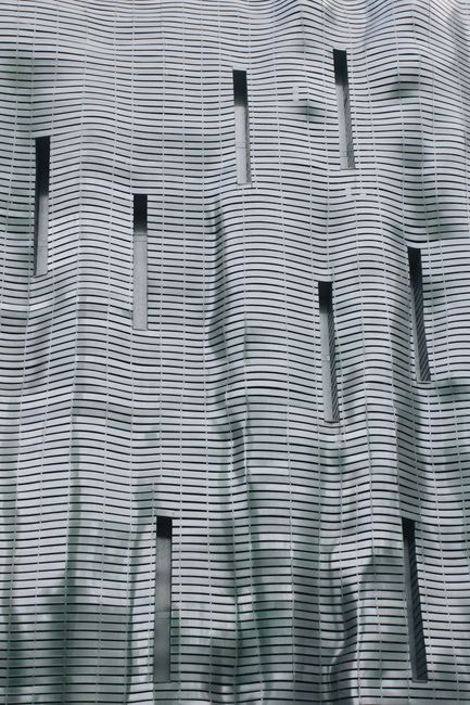 A striking modern facade with a unique wavy design in Poznań, Poland.