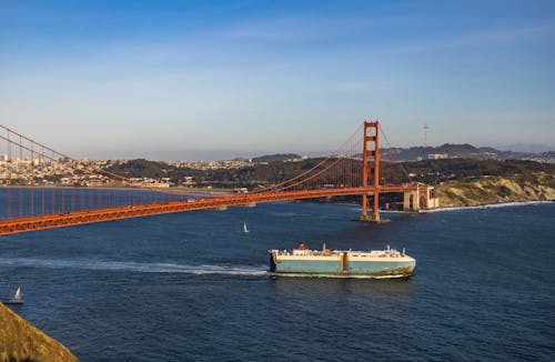 Free A Ship Passes Under the Golden Gay Bridge Stock Photo