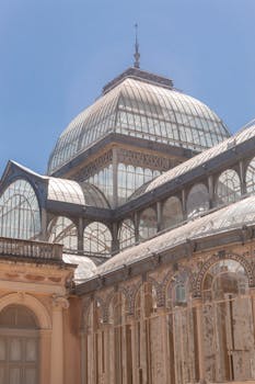 Stunning view of the Palacio de Cristal under a clear blue sky, Madrid.
