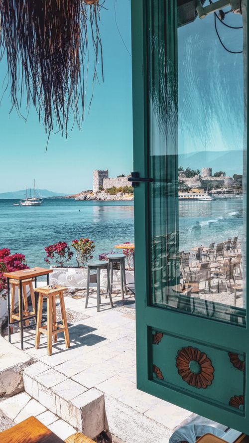 Free Discover a tranquil seaside setting in Muğla, Turkey with turquoise waters and a cozy dining area. Stock Photo
