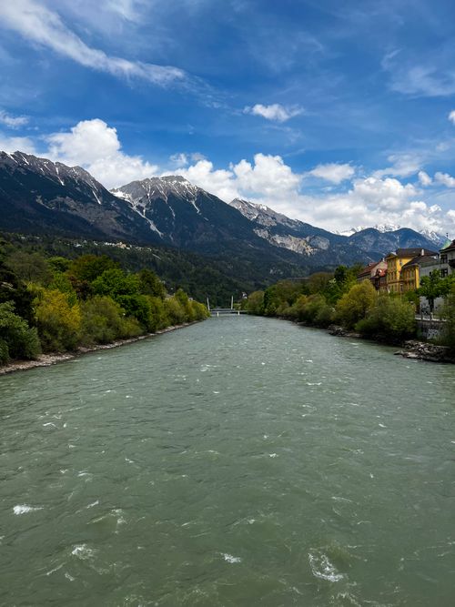 Free Serene mountain landscape with a river in Innsbruck, showcasing lush greenery and snow-capped peaks. Stock Photo