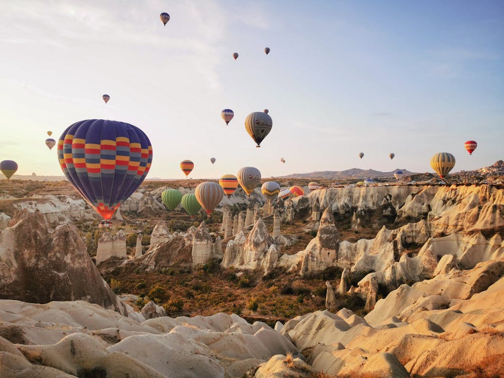 Hot Air Balloons Floating over Rocky Mountains · Free Stock Photo