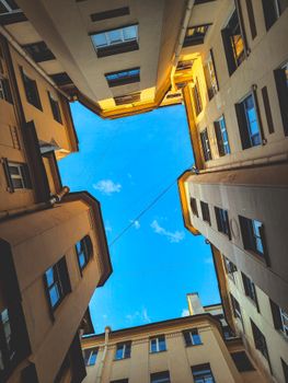 Brown buildings surround a blue sky, captured from a low angle. Urban architecture marvel.