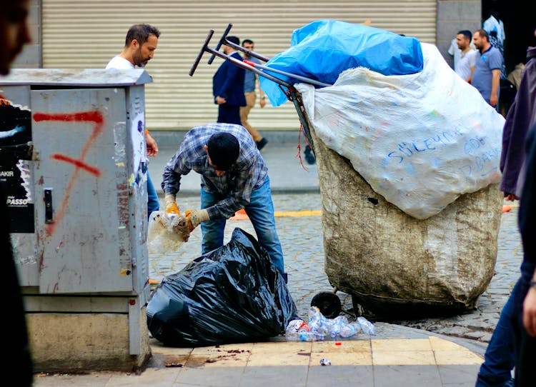 A Man Collecting Garbage On The Street