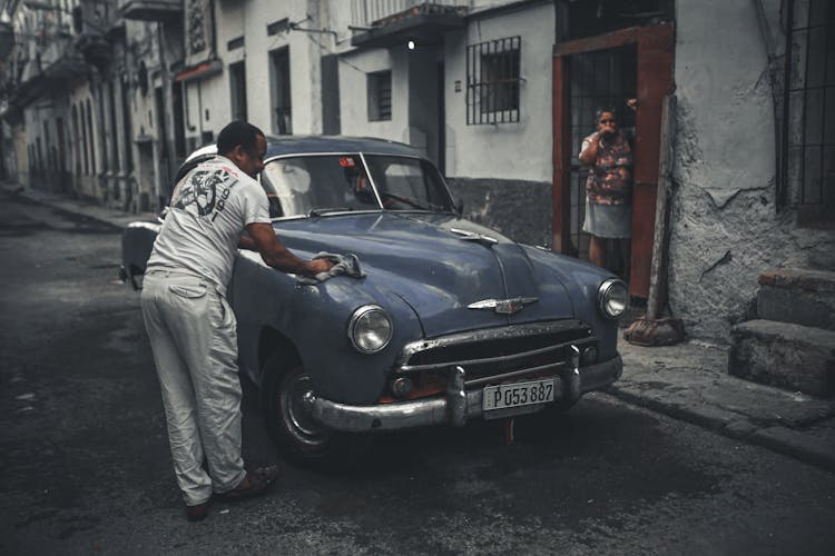 A Man Cleaning His Car On The Street