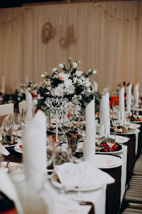 Free Beautifully arranged wedding reception table with floral centerpiece and fine dining settings. Stock Photo