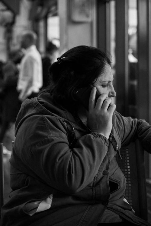 Free Black and white photo of woman talking on cellphone indoors. Stock Photo
