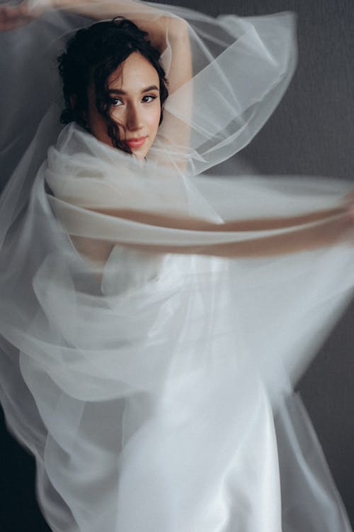 Woman in White Dress and Veil Looking at the Camera
