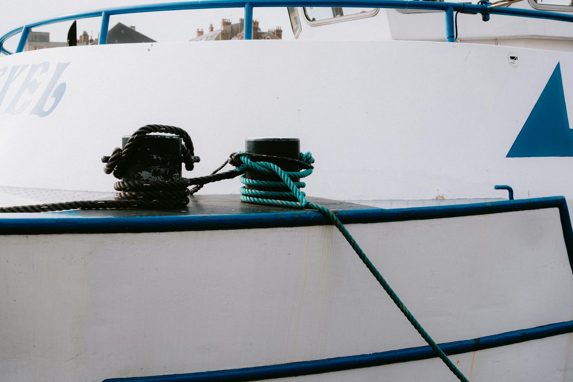 Detailed view of mooring ropes tied to posts on a docked yacht in a harbor.