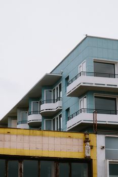 Contemporary multi-story building with blue facade and balconies, ideal for modern architecture themes.