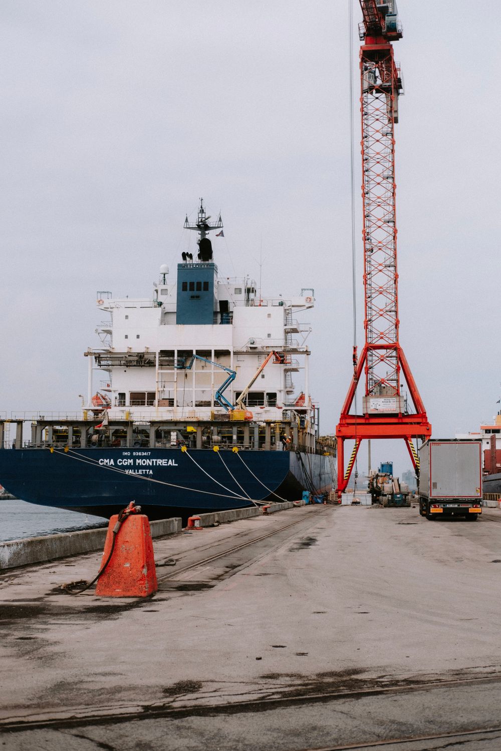 Container ship at a port with cranes and freight trucks