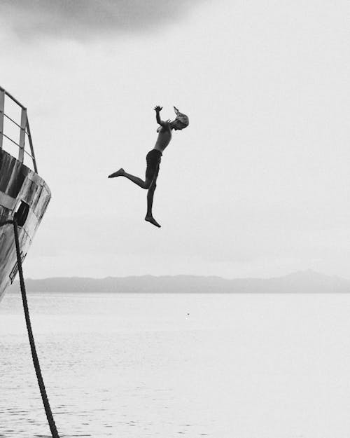 Free Man Jumping from a Ship to Water  Stock Photo