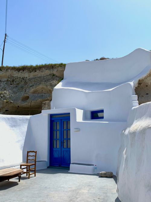 Free Scenic view of a traditional whitewashed building with blue door in Megalochori, Greece. Stock Photo