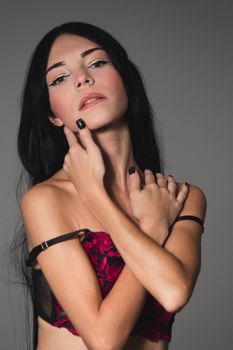 Close-up portrait of a woman in elegant lingerie with a confident pose.