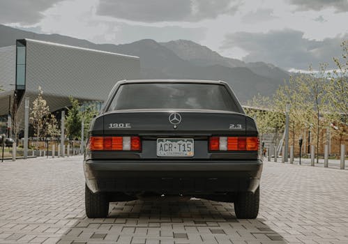 A classic Mercedes Benz 190E parked outdoors with a scenic mountain backdrop in Colorado.