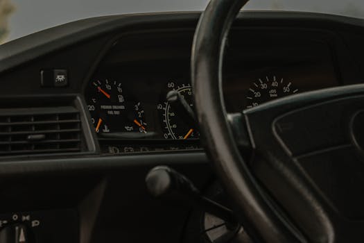 Detailed view of a vintage car's dashboard, gauges, and steering wheel.