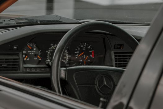Close-up of a Mercedes-Benz dashboard and steering wheel, showcasing classic luxury design.