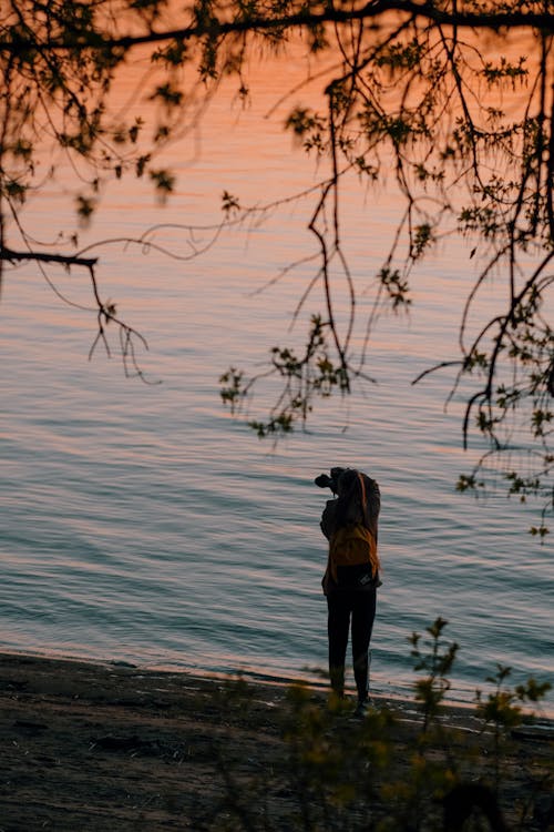 Woman in Black Jacket and Black Pants Standing on Water